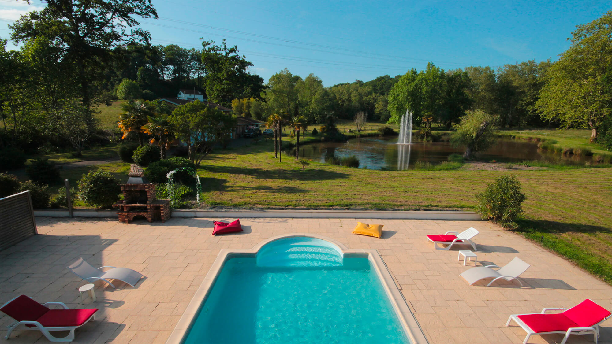 Vue sur la piscine, le parc et le lac du Domaine du Haou